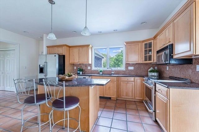 89 Standish Rd, Bourne, MA 02562 - kitchen featuring appliances with stainless steel finishes, a sink, a kitchen bar, backsplash, and light brown cabinets