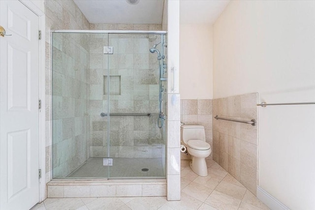 89 Standish Rd, Bourne, MA 02562 - bathroom with toilet, a stall shower, tile patterned flooring, tile walls, and wainscoting