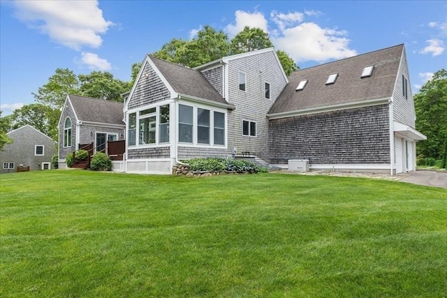 89 Standish Rd, Bourne, MA 02562 - rear view of house featuring roof with shingles, a sunroom, and a lawn