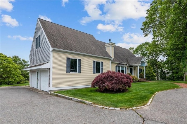 89 Standish Rd, Bourne, MA 02562 - view of side of home featuring a garage, a lawn, driveway, a shingled roof, and a chimney