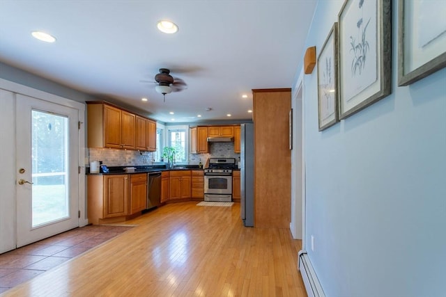 3846 Pawtucket, East Providence, RI 02915 - kitchen featuring appliances with stainless steel finishes, under cabinet range hood, ceiling fan, backsplash, and light wood finished floors