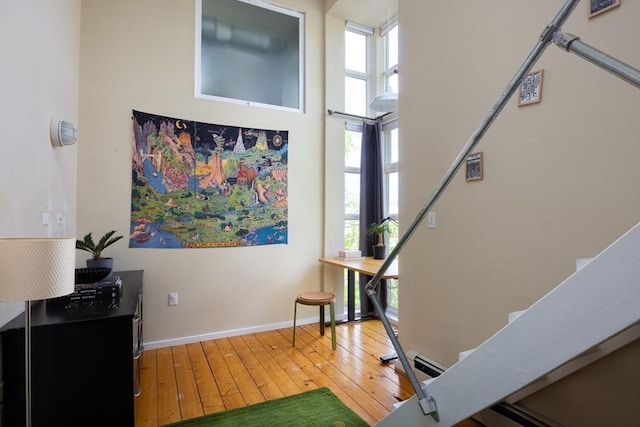sitting room featuring hardwood / wood-style flooring, healthy amount of natural light, and baseboards