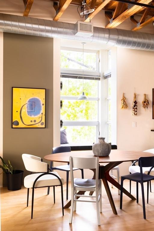 dining space featuring wood finished floors, breakfast area, and beam ceiling