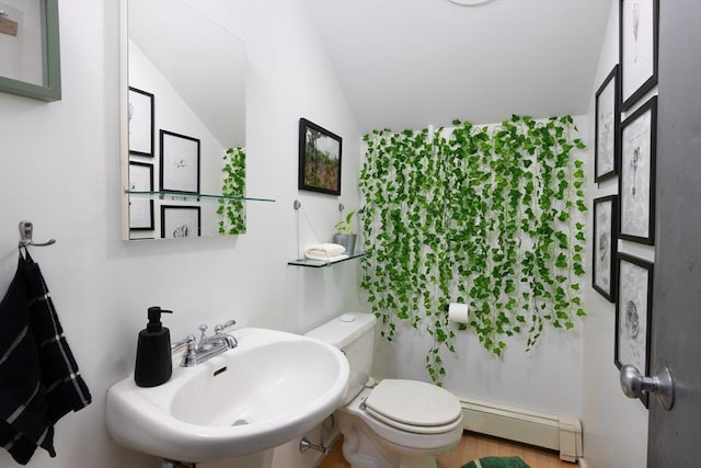 bathroom with a baseboard radiator, a sink, toilet, and lofted ceiling