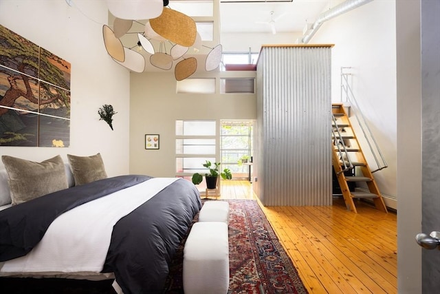 bedroom with hardwood / wood-style floors and multiple windows