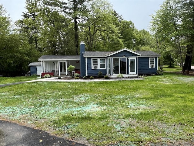 view of front of house featuring a chimney and a front lawn