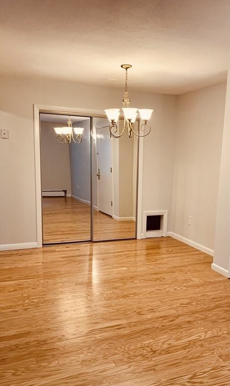 5 Woodsum Dr Unit 7, Braintree, MA 02184 - unfurnished living room with a chandelier, light wood-type flooring, and baseboards