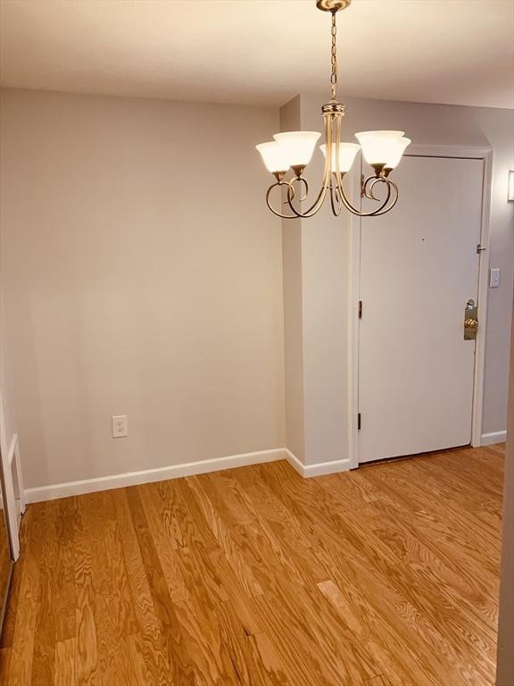 5 Woodsum Dr Unit 7, Braintree, MA 02184 - unfurnished room with light wood-type flooring, a chandelier, and baseboards