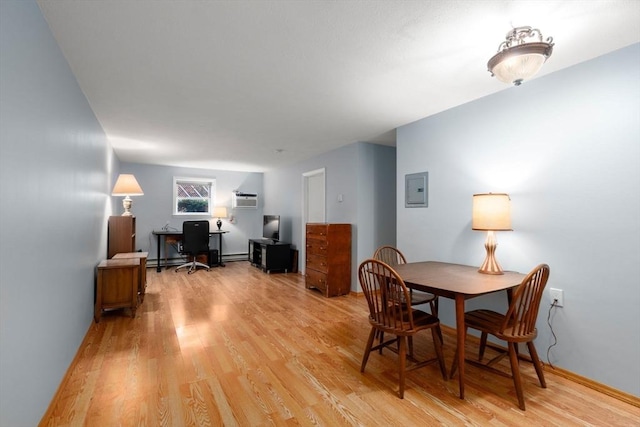 dining room with an AC wall unit, light wood-style flooring, electric panel, and a baseboard radiator