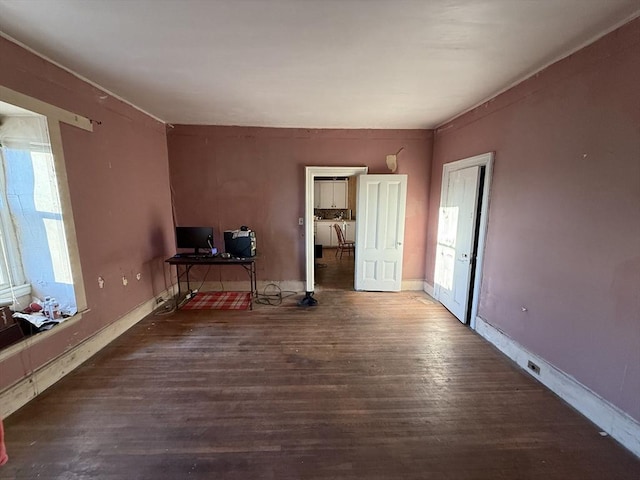 interior space with baseboards and dark wood-style flooring