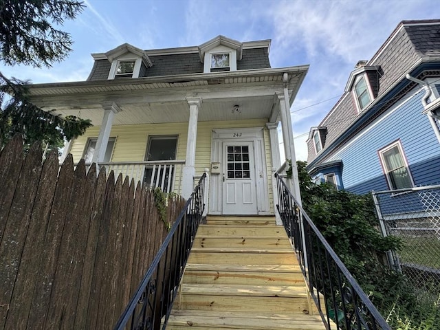 view of front of property featuring a shingled roof and mansard roof