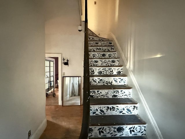 staircase featuring concrete floors and a high ceiling