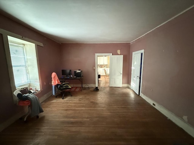 living area featuring baseboards and dark wood-type flooring