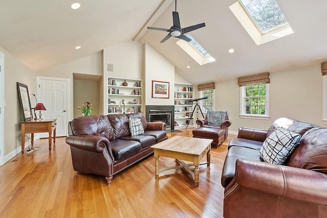 114 Hunters Ridge Rd, Concord, MA 01742 - living room with a skylight, light wood-type flooring, a fireplace with flush hearth, a ceiling fan, and recessed lighting