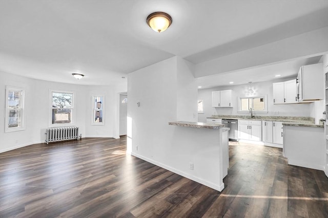 kitchen featuring light stone countertops, radiator, dark wood-type flooring, dishwasher, and white cabinetry