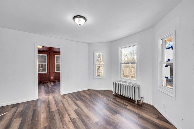 empty room featuring dark hardwood / wood-style flooring and radiator heating unit