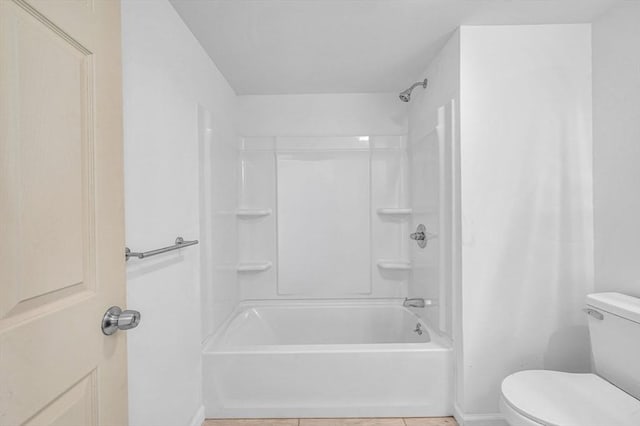 bathroom featuring tile patterned floors, toilet, and bathtub / shower combination