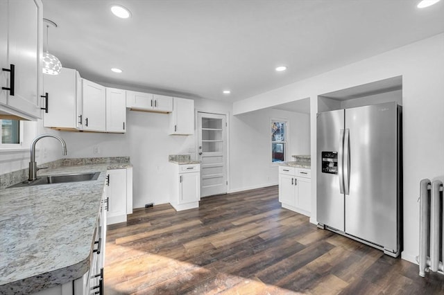 kitchen with white cabinetry, sink, dark hardwood / wood-style floors, stainless steel fridge, and decorative light fixtures