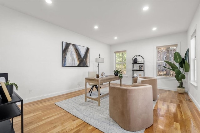 office space featuring baseboards, light wood finished floors, and recessed lighting