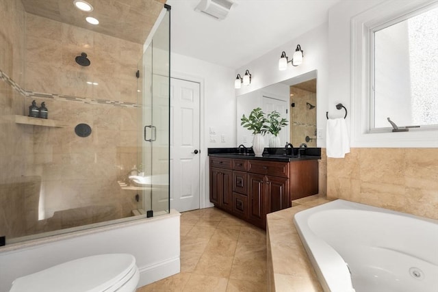 bathroom featuring a garden tub, double vanity, toilet, a stall shower, and a sink