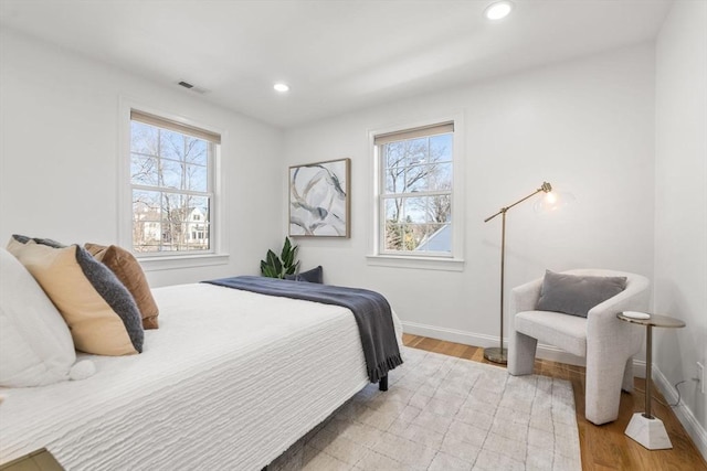 bedroom featuring light wood-style flooring, visible vents, baseboards, and recessed lighting