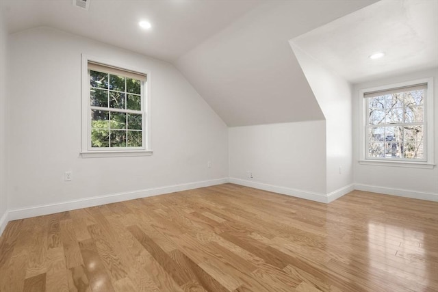 additional living space with plenty of natural light, light wood-style flooring, and baseboards