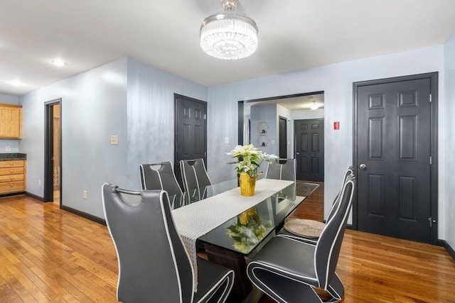 dining area featuring light hardwood / wood-style flooring and a chandelier