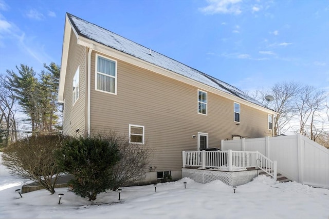 snow covered rear of property featuring a wooden deck