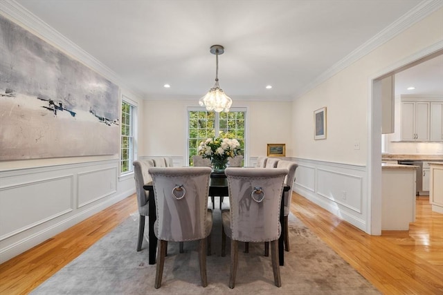 dining space with light hardwood / wood-style floors, a notable chandelier, and ornamental molding