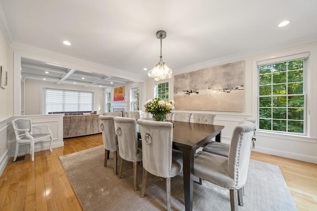 dining room featuring a wealth of natural light, crown molding, light hardwood / wood-style floors, and coffered ceiling