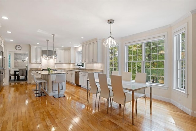 dining area featuring light hardwood / wood-style flooring and ornamental molding