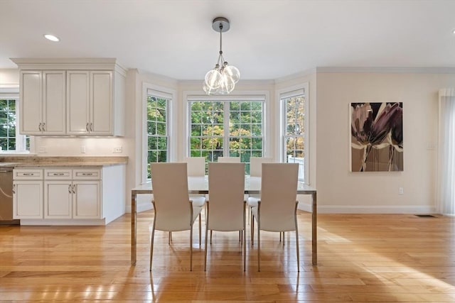 dining space with crown molding, plenty of natural light, and light hardwood / wood-style floors