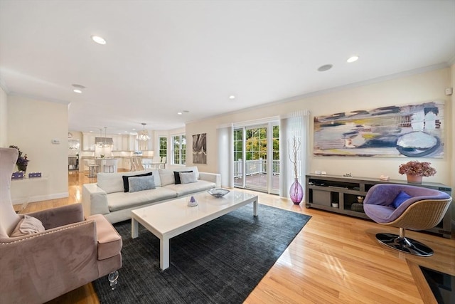 living room with crown molding and light hardwood / wood-style flooring