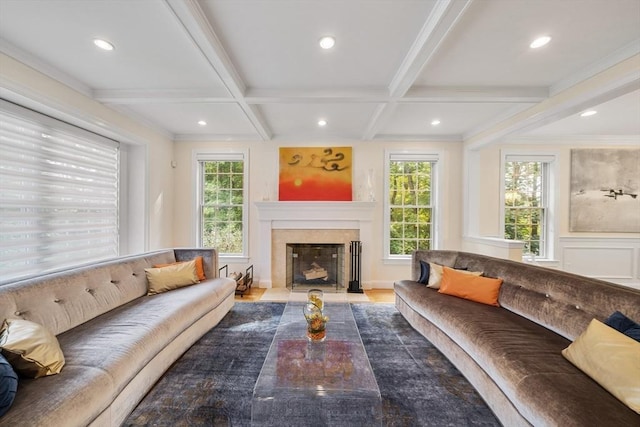 living room featuring beamed ceiling, ornamental molding, a wealth of natural light, and coffered ceiling