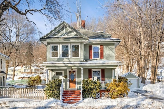 view of front of property featuring covered porch, an outdoor structure, a chimney, and fence