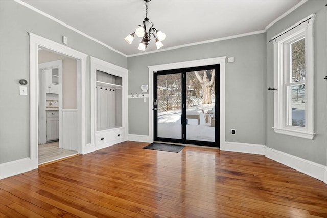 interior space with crown molding, hardwood / wood-style floors, and a notable chandelier