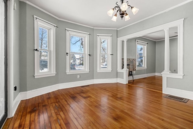 foyer with ornate columns, visible vents, ornamental molding, baseboards, and hardwood / wood-style flooring