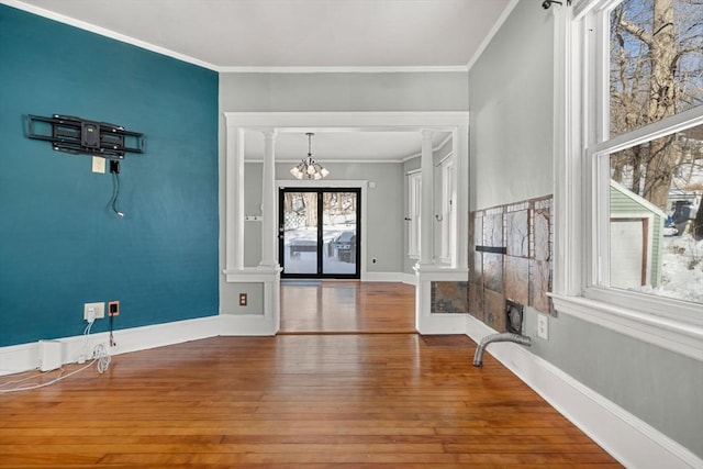 entrance foyer featuring ornamental molding, baseboards, a notable chandelier, and hardwood / wood-style floors