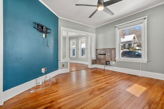 interior space featuring crown molding, light wood-type flooring, a fireplace, and baseboards