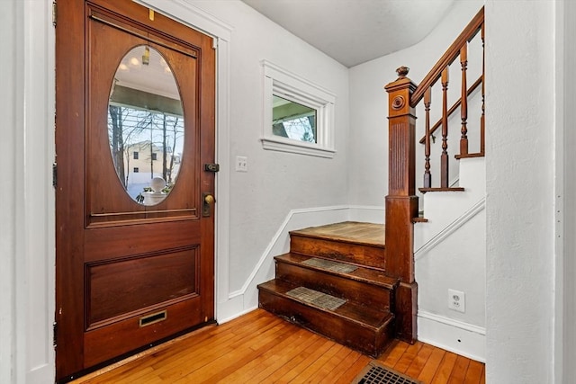 entryway with light wood-type flooring, stairway, and a wealth of natural light