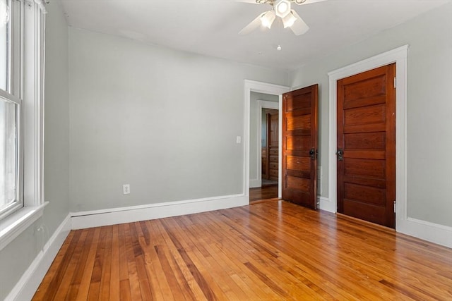 unfurnished room with ceiling fan, light wood-style flooring, and baseboards