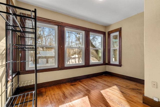 unfurnished room with hardwood / wood-style flooring and baseboards