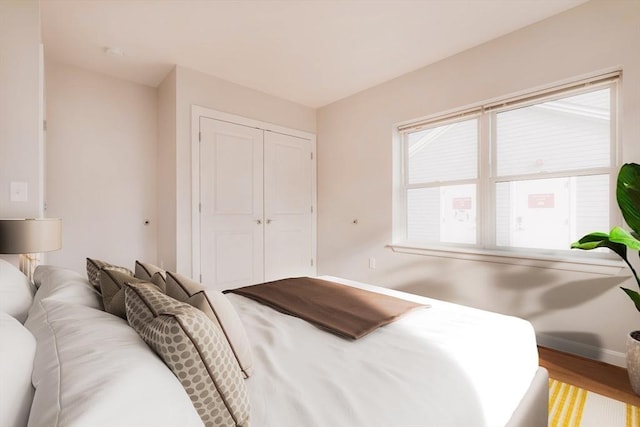 bedroom featuring a closet, baseboards, and wood finished floors