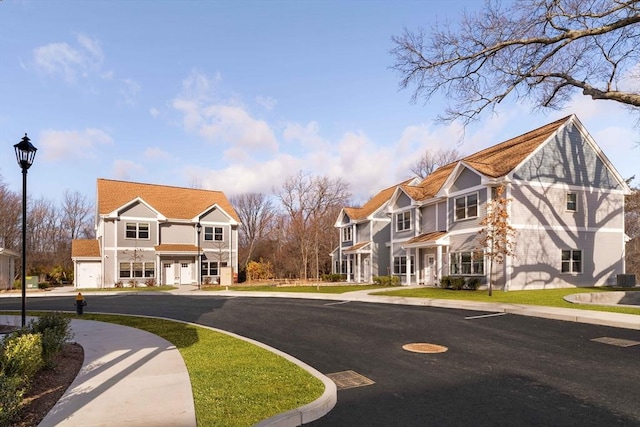 view of road featuring sidewalks, a residential view, curbs, and street lighting