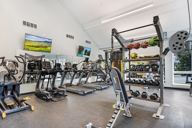 exercise room with visible vents and high vaulted ceiling