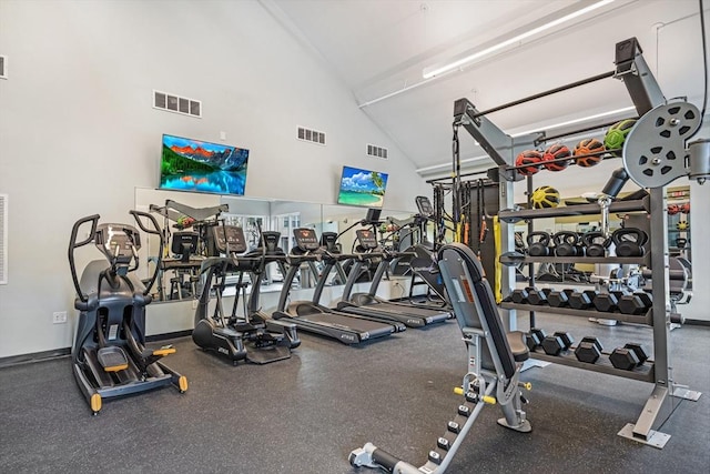 exercise room with visible vents and high vaulted ceiling