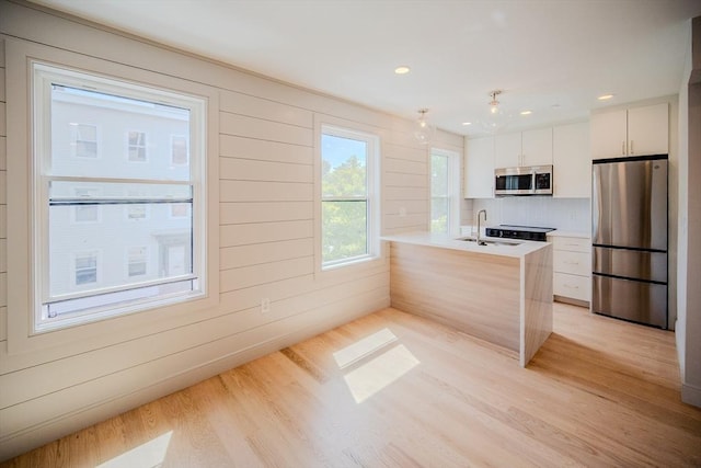 88 Maverick St Unit 2, Boston, MA 02128 - kitchen featuring stainless steel appliances, light wood finished floors, white cabinets, a peninsula, and recessed lighting