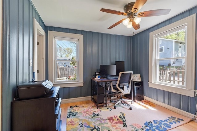 office featuring baseboards, light wood-style floors, and ceiling fan