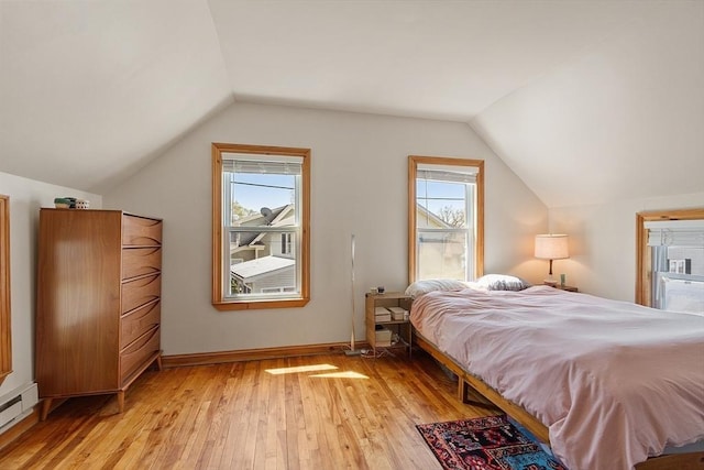 bedroom with lofted ceiling, multiple windows, a baseboard radiator, and light wood-type flooring