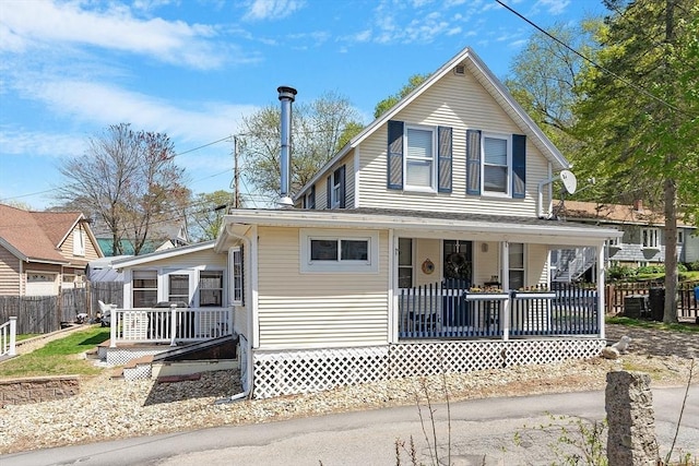 farmhouse with a porch and fence